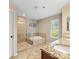 Bathroom features a glass-enclosed shower, soaking tub, granite-topped vanity and bright window at 7325 Forrest Rader Dr, Mint Hill, NC 28227