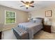Bedroom features neutral carpet, ceiling fan, natural light, and a tufted storage bench at 7325 Forrest Rader Dr, Mint Hill, NC 28227