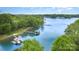 Picturesque aerial view of a lake house with a private dock and boat storage, surrounded by mature trees and calm waters at 7525 Windy Pine Cir, Denver, NC 28037