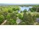 Stunning aerial view of a lakefront property surrounded by lush greenery with views of the expansive lake at 7525 Windy Pine Cir, Denver, NC 28037