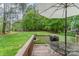 Spacious back deck with a grill, umbrella, and seating area overlooking a large green backyard with mature trees at 7525 Windy Pine Cir, Denver, NC 28037