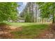 Sprawling backyard with lush greenery, mature trees lining the property, and a glimpse of the home's exterior at 7525 Windy Pine Cir, Denver, NC 28037