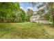Large, well-manicured backyard with a view of the house, deck, and surrounding trees creating a private oasis at 7525 Windy Pine Cir, Denver, NC 28037