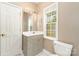 A well-lit bathroom features a single vanity, a window, and toilet at 7525 Windy Pine Cir, Denver, NC 28037