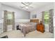 Bedroom featuring neutral gray walls, a wooden bed frame, and natural light from two windows at 7525 Windy Pine Cir, Denver, NC 28037