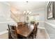 Dining area featuring a large wooden table and chairs, with natural light and a view of the staircase at 7525 Windy Pine Cir, Denver, NC 28037