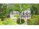 Charming two-story home with a brick facade, attached garage, and inviting front porch surrounded by mature trees at 7525 Windy Pine Cir, Denver, NC 28037