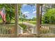 Eye-level view from front door, through the columns, showing a driveway, flower beds, and the large front yard at 7525 Windy Pine Cir, Denver, NC 28037
