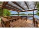 Covered wooden deck overlooking the lake, providing a serene spot to enjoy waterfront views and outdoor relaxation at 7525 Windy Pine Cir, Denver, NC 28037