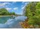 Picturesque lake view with calm waters, surrounded by trees and docks, offering serene waterfront living at 7525 Windy Pine Cir, Denver, NC 28037