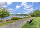 Scenic lakefront path with benches, lush greenery, and calming lake views, perfect for leisurely strolls and relaxation at 7525 Windy Pine Cir, Denver, NC 28037