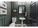 Elegant powder room featuring wainscoting, pedestal sink, and black fixtures at 7811 Compton Ct, Charlotte, NC 28270