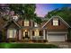 Charming two-story brick home featuring a welcoming front porch with white columns and manicured landscaping at 7811 Compton Ct, Charlotte, NC 28270