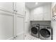 Clean laundry room with white cabinets, modern washer and dryer, and black and white tiled floor at 7811 Compton Ct, Charlotte, NC 28270