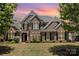 Beautiful two-story brick home with a manicured lawn, black shutters, and mature trees enhancing its curb appeal at 10202 Alouette Dr, Waxhaw, NC 28173