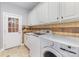 Functional laundry room with tile backsplash, storage cabinets, and front loading washer and dryer at 10202 Alouette Dr, Waxhaw, NC 28173