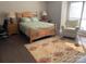 Cozy bedroom with a wooden bed frame, patterned rug, and natural light from a large window at 11106 Harrowfield Rd, Charlotte, NC 28226