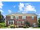 Rear exterior view of the red brick home with deck overlooking the landscaped backyard at 11917 Chevis Ct, Charlotte, NC 28277