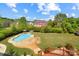 Aerial view of a backyard with a pool, patio area, lush landscaping, and green lawn at 11917 Chevis Ct, Charlotte, NC 28277