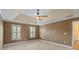 Bright bedroom featuring neutral carpet, tray ceiling, crown molding, and plantation shutters at 11917 Chevis Ct, Charlotte, NC 28277