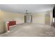 Open bonus room with neutral carpeting, ceiling fan, and adjacent access to other rooms at 11917 Chevis Ct, Charlotte, NC 28277