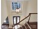 Inviting foyer with a decorative light fixture, beautiful entry door, and staircase at 11917 Chevis Ct, Charlotte, NC 28277