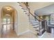 Inviting foyer with beautiful staircase, archway, and views of the living room and front yard at 11917 Chevis Ct, Charlotte, NC 28277
