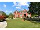 Beautiful red brick home with manicured front yard and landscaping on a bright day at 11917 Chevis Ct, Charlotte, NC 28277