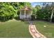 Secluded backyard gazebo with a stone paver path, garden, and lawn at 11917 Chevis Ct, Charlotte, NC 28277