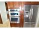 Stainless steel refrigerator and double oven with wood cabinets at 11917 Chevis Ct, Charlotte, NC 28277