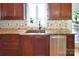 Kitchen area with copper sink, light backsplash, and wood cabinets at 11917 Chevis Ct, Charlotte, NC 28277