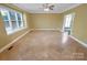 Bright living room featuring neutral walls, tiled floors, large windows, and a ceiling fan at 11917 Chevis Ct, Charlotte, NC 28277