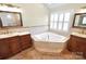 Charming main bathroom with a garden tub, double vanities, decorative tile, and natural light at 11917 Chevis Ct, Charlotte, NC 28277