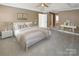 Spacious main bedroom featuring a tray ceiling, a ceiling fan, and neutral carpet flooring at 11917 Chevis Ct, Charlotte, NC 28277