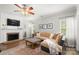 Cozy living room with brick fireplace, ceiling fan, and plush sectional sofa at 12328 Chickasaw Dr, Huntersville, NC 28078