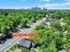 Aerial view of the home nestled among lush greenery, showcasing the neighborhood and city skyline at 1517 Parkwood Ave, Charlotte, NC 28205