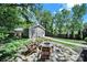 Relaxing backyard with stone fire pit and comfortable seating, surrounded by mature trees and lush greenery at 1517 Parkwood Ave, Charlotte, NC 28205