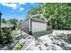 Detached garage with an automatic white door, a small gate, and a paved driveway with stone landscape at 1517 Parkwood Ave, Charlotte, NC 28205