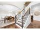 Staircase with decorative wrought iron spindles and wood banister leads to the upper level, adjacent to dining area at 15702 Guthrie Dr, Huntersville, NC 28078