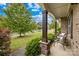 Inviting front porch with decorative columns, comfortable seating, and views of the landscaped front yard at 15702 Guthrie Dr, Huntersville, NC 28078