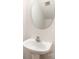 Modern half-bath with pedestal sink, round mirror, and minimalist design at 1620 Crandon Dr, Charlotte, NC 28216