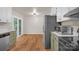 Open kitchen with stainless appliances, wood flooring, and sliding glass door access to deck at 177 Candlestick Dr, Statesville, NC 28625