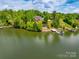Aerial view of a waterfront home with a private dock surrounded by lush greenery and a serene lake at 181 Edgewater Rd, Hickory, NC 28601