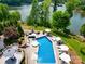 Aerial view of a sparkling backyard pool and hot tub overlooking a lake with mature landscaping at 181 Edgewater Rd, Hickory, NC 28601