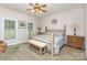 Comfortable bedroom with a wooden bed frame, soft blue bedding, and natural light streaming through two bright windows at 182 Meek Rd, Gastonia, NC 28056