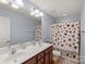 Bright bathroom features a double vanity, a colorful shower curtain, and tile floors at 1948 Winpole Ln, Charlotte, NC 28273