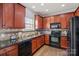 Kitchen with stainless steel appliances, granite countertops, dark wood cabinets, and hardwood floors at 1948 Winpole Ln, Charlotte, NC 28273