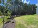 View of a manicured backyard showing green grass, flower beds, and pine trees at 2028 Cedar Falls Dr # 10, Waxhaw, NC 28173