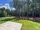 A concrete patio, green grass, and tall pine trees in a backyard at 2028 Cedar Falls Dr # 10, Waxhaw, NC 28173