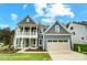Charming two-story home with a blue exterior, covered porch, two-car garage, and well-manicured lawn at 2028 Cedar Falls Dr # 10, Waxhaw, NC 28173